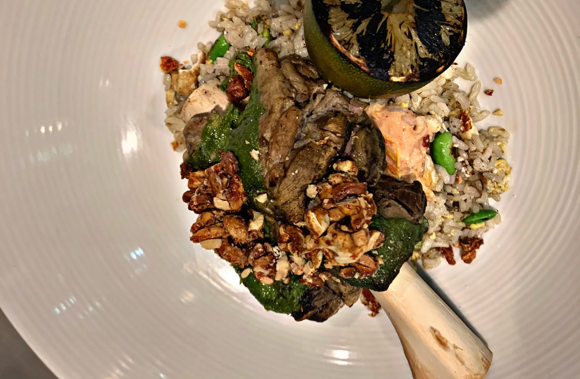 Braised lamb shank over fried rice with charred lime